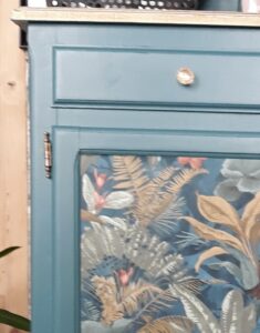 Commode bleu canard rénovée avec des motifs floraux