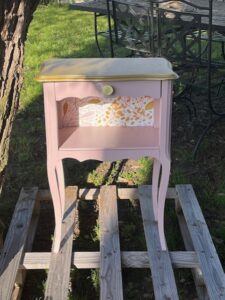 Table de chevet rose poudrée rénovée avec motifs floraux